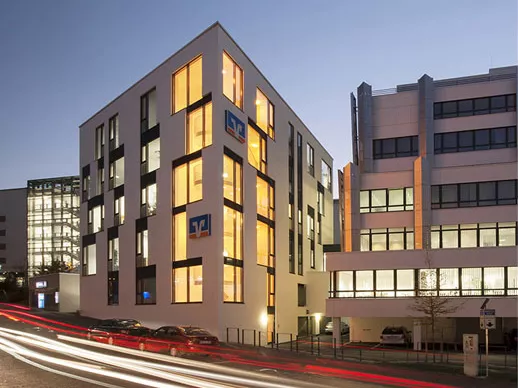 Raiffeisenbank Kempten-Oberallgäu in der Dämmerung, Fassade in gelbem Licht
