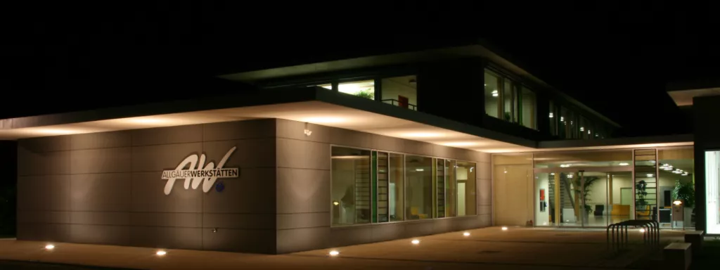 Allgäuer Werkstätten bei Nacht, beleuchtete Fassade